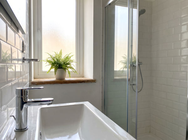 Clean bathroom tap and glass shower screen in a Maltese apartment