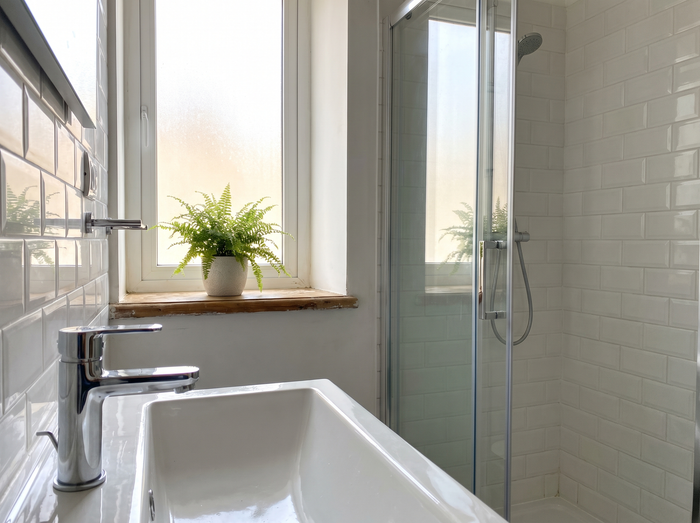 Clean bathroom tap and glass shower screen in a Maltese apartment